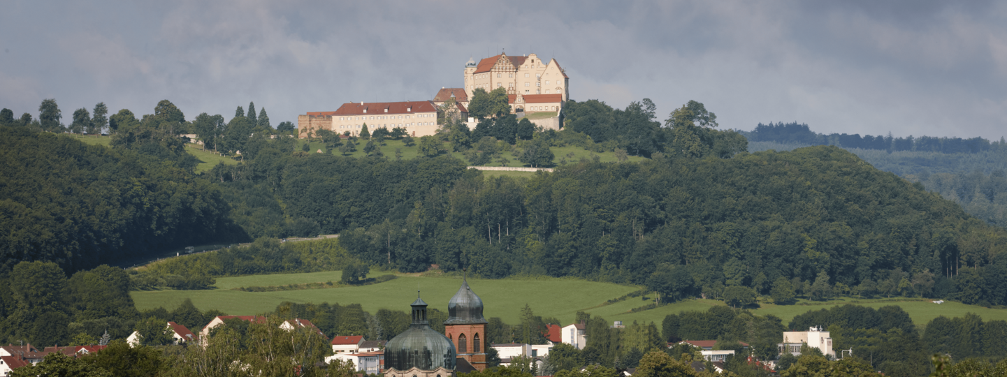 Schloss Kapfenburg Gesamtansicht auf bewaldetem Berg