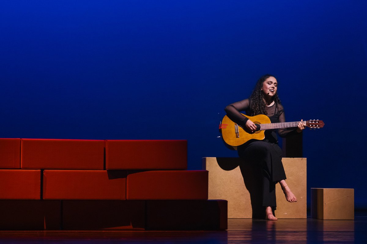 Person mit Gitarre auf der Bühne